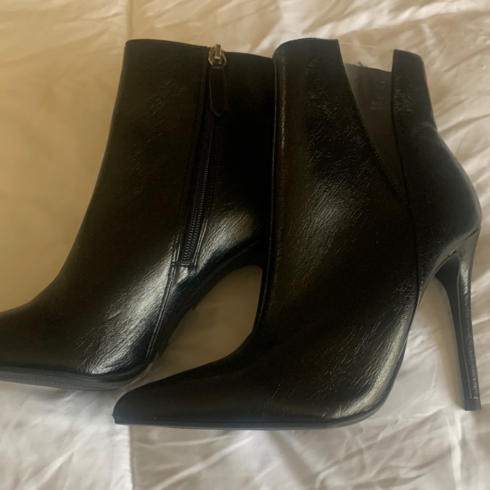 Black pointy booties. Clear plastic on the side. Never used